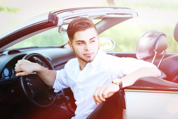 Jonge man in cabriolet, buitenshuis — Stockfoto