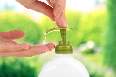 Doğa arka plan üzerinde sıvı sabun kullanarak eller
