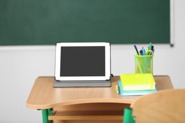 İleti örneği ve yazı tahtası arka plan üzerinde sınıfta tablet ile ahşap masa