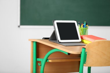 İleti örneği ve yazı tahtası arka plan üzerinde sınıfta tablet ile ahşap masa