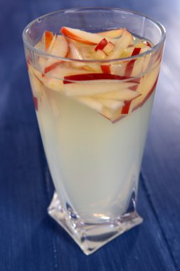 Ahşap arka planda bir bardak elma şarabı.