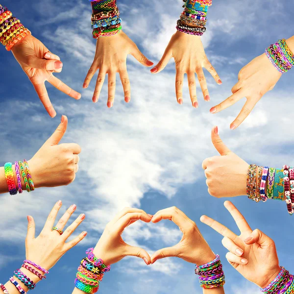 Female hands with bracelets on sky background — Stock Photo, Image