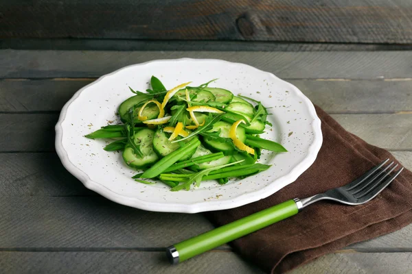 Salada verde n prato no fundo de madeira — Fotografia de Stock