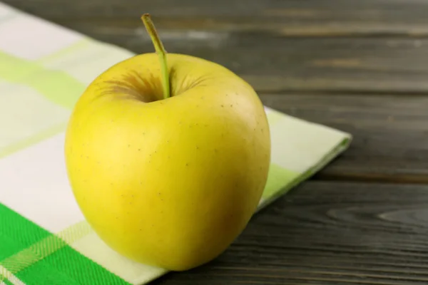 Jablko s ubrouskem na dřevěný stůl, detail — Stock fotografie