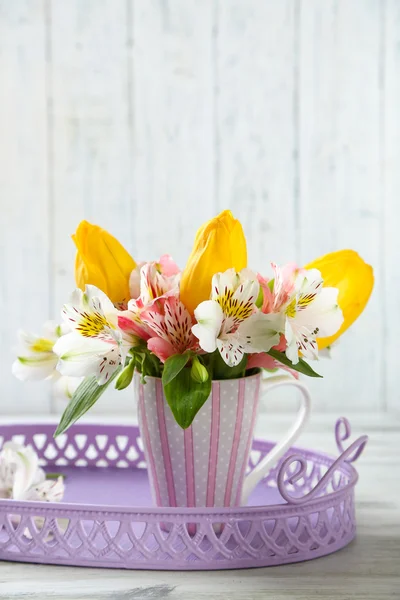 Hermosas flores en copa, sobre fondo de madera — Foto de Stock