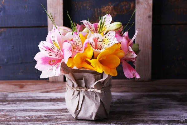 Beautiful flowers in vase on wooden background — Stock Photo, Image