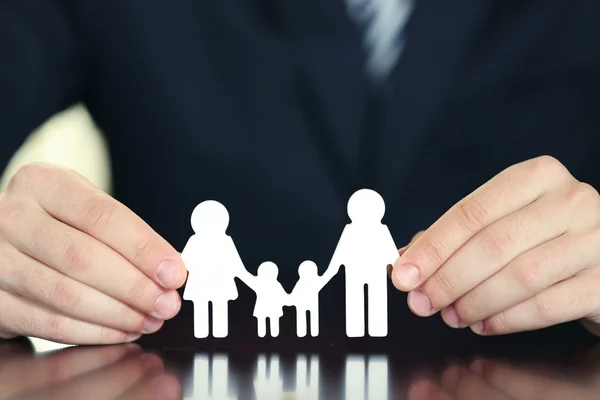 Manos femeninas y familia de cadenas en mesa de madera, primer plano — Foto de Stock