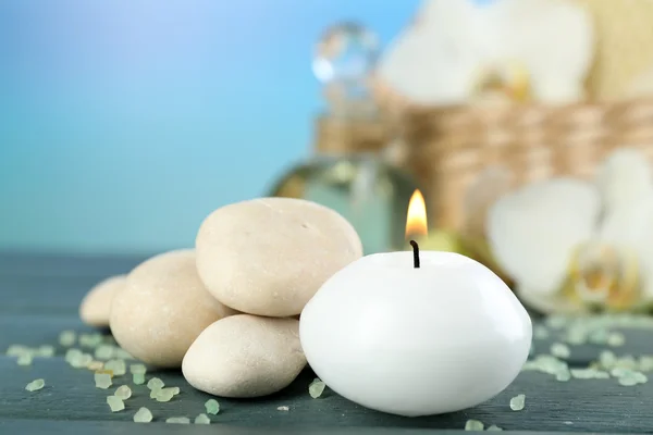 Zátiší s svíčku, oblázků a lázeňské léčby na dřevěný stůl, na světlé pozadí — Stock fotografie