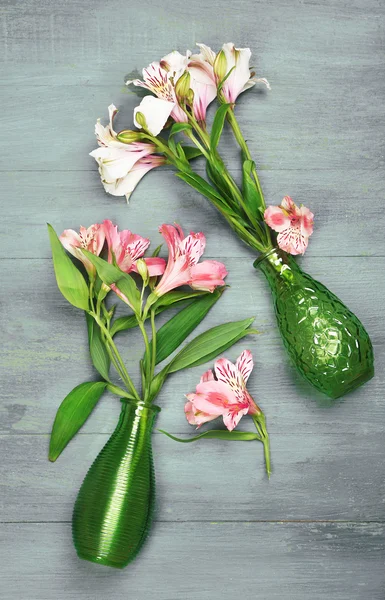 Beautiful alstroemeria in vases on wooden background — Stock Photo, Image