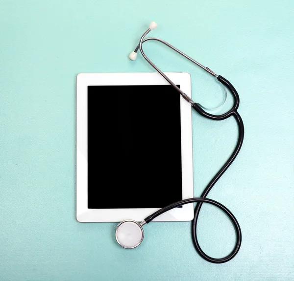 Medical tablet with stethoscope on light background — Stok fotoğraf