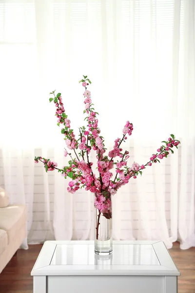 Spring bouquet in vase, on table, on home interior background