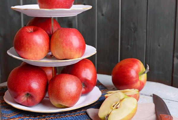Смачні стиглі яблука на підносі на дерев'яному фоні — стокове фото