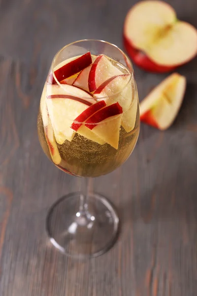 Glass of apple cider with fruits on wooden background — Stock Photo, Image