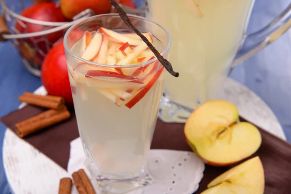 Glass and carafe of apple cider with fruits and spices on table close up — Stock Photo, Image