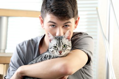 yakışıklı delikanlı ile evde basamaklarında oturan sevimli kedi