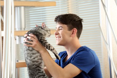 yakışıklı delikanlı ile evde basamaklarında oturan sevimli kedi