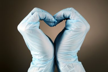 Doktor eller üzerinde kalp şekil verme arka plan gri