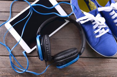 spor ayakkabı ve tablet ahşap arka plan üzerinde kulaklık