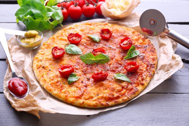 fesleğen ve parşömen üzerine ahşap masa, closeup kiraz domates pizza