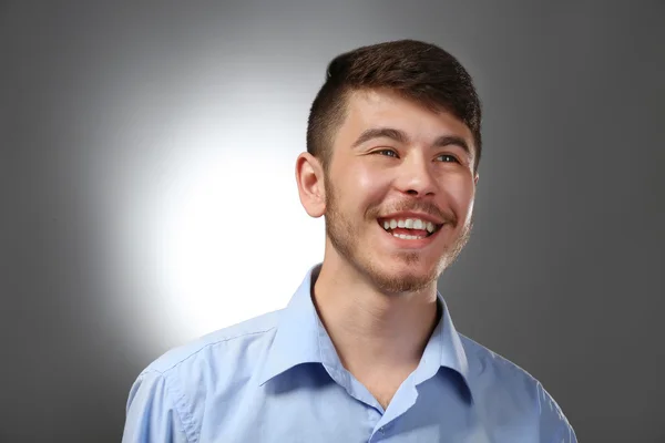 Portrait of smiling man on gray background — Stock Photo, Image