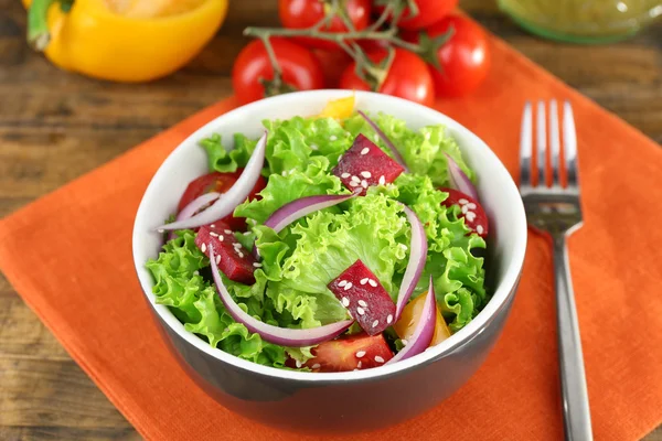 Tigela de salada verde fresca na mesa com guardanapo, close-up — Fotografia de Stock