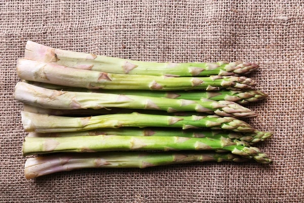 Asperges fraîches sur fond de sac — Photo