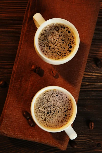 Xícaras de café em guardanapo na mesa de perto — Fotografia de Stock