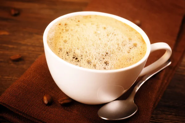 Secangkir kopi di serbet di atas meja tutup — Stok Foto