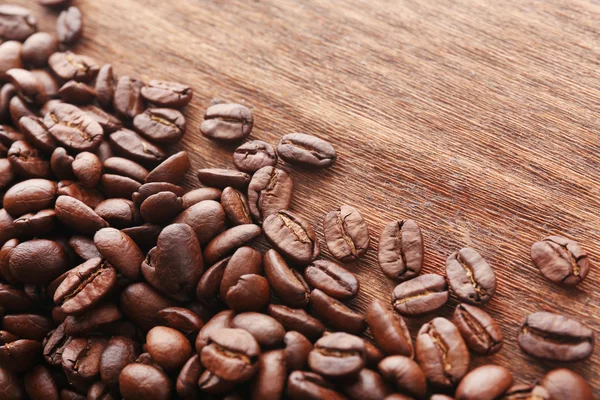 Granos de café sobre fondo de madera — Foto de Stock