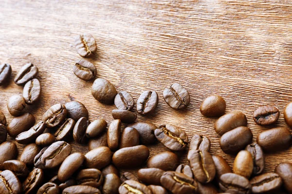 Koffiebonen op houten ondergrond — Stockfoto