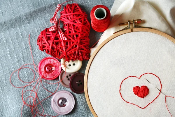El aro de bordado con tela e hilos de coser rojos en la mesa de cerca — Foto de Stock