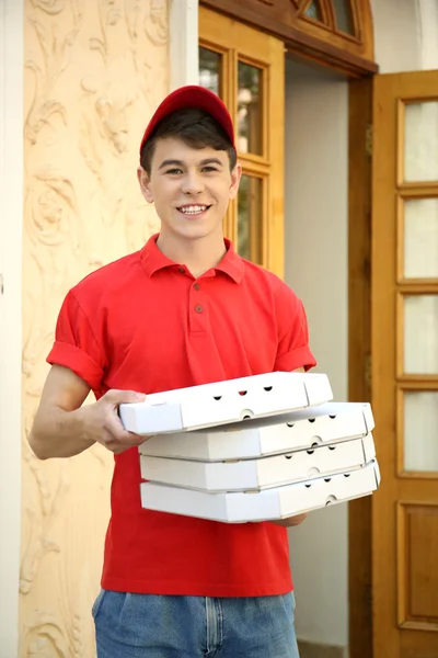 Szállít a pizza doboz ház közelében, fiatal férfi — Stock Fotó