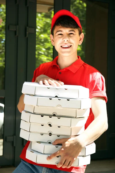 年轻男子送比萨盒附近的房子 — 图库照片