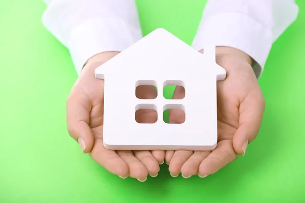 Vrouwelijke handen met huis op kleur achtergrond — Stockfoto