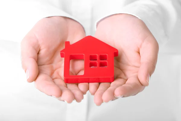 Mani femminili che tengono la casa su sfondo di colore — Foto Stock