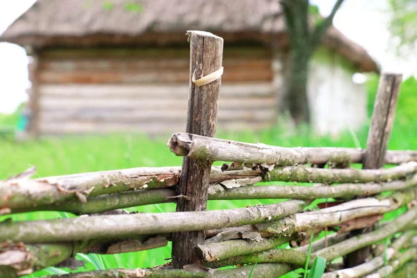 Wicker rustic fence in garden on grass background — Stock Photo, Image