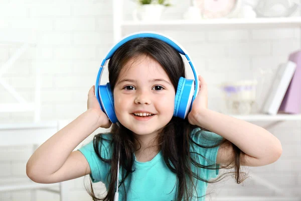 Hermosa niña escuchando música en la habitación — Foto de Stock