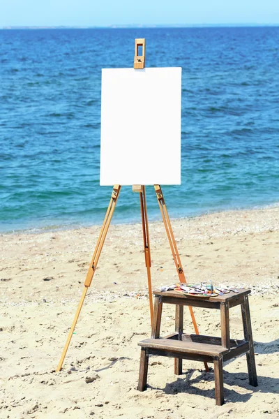 Easel with canvas on beach — Stock Photo, Image