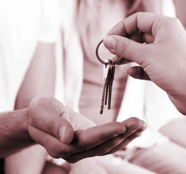 Agente imobiliário dando chaves para jovem casal, close-up — Fotografia de Stock