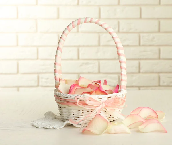 Wedding basket with roses petals on table, on light background — Stock Photo, Image