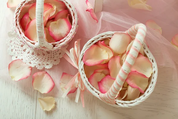 Cestas de casamento com pétalas de rosas na mesa, no fundo claro — Fotografia de Stock