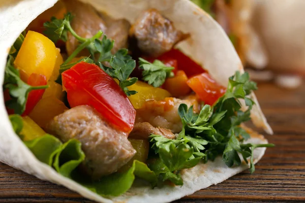 Домашнее вкусное буррито с овощами на доске, на деревянном фоне — стоковое фото