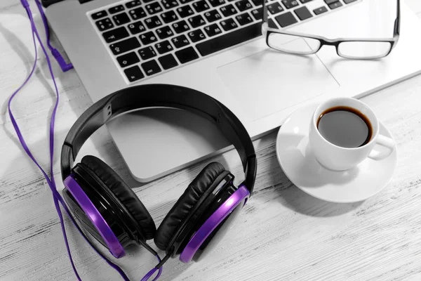 Local de trabalho com fones de ouvido na mesa de perto — Fotografia de Stock