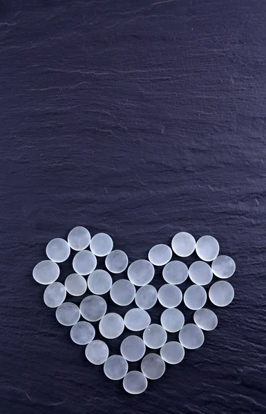 Dekorativní kameny ve tvaru srdce na šedém pozadí — Stock fotografie