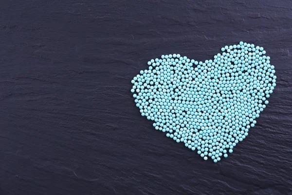 Colorful beads in heart shape on grey background — Φωτογραφία Αρχείου