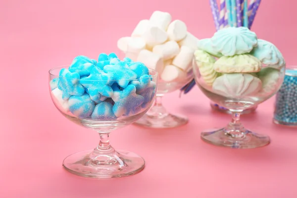 Fluffy candies in glassware on pink background — Stock Photo, Image