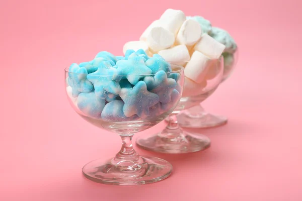 Fluffy candies in glassware on pink background — Stock Photo, Image