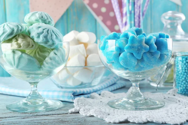 Dulces caramelos en cristalería sobre mesa de madera, primer plano — Foto de Stock