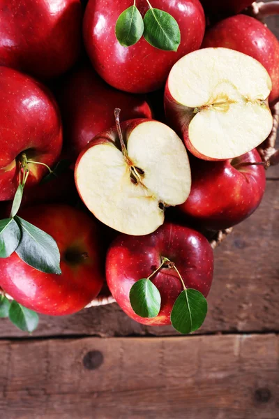 Roter Apfel im Weidenkorb auf Holztisch, Draufsicht — Stockfoto