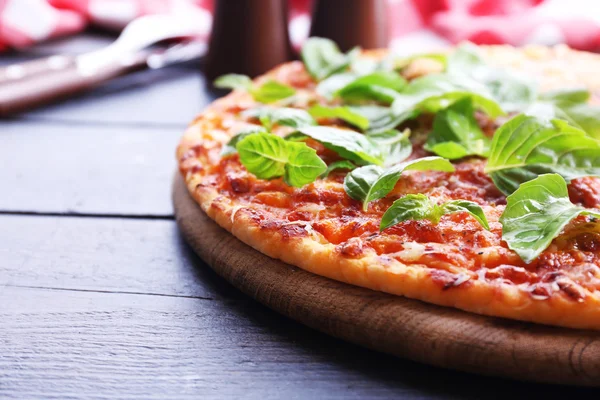 Pizza com manjericão na mesa de madeira, close-up — Fotografia de Stock